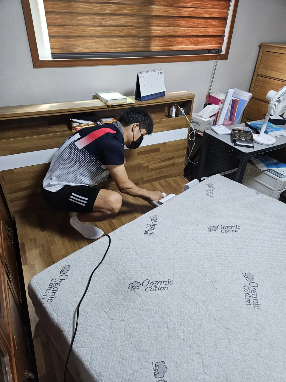 헤드보드 쪽 윗면을 침구청소기로 흡입하는 모습 — 침구청소기 매트리스 케어 1단계