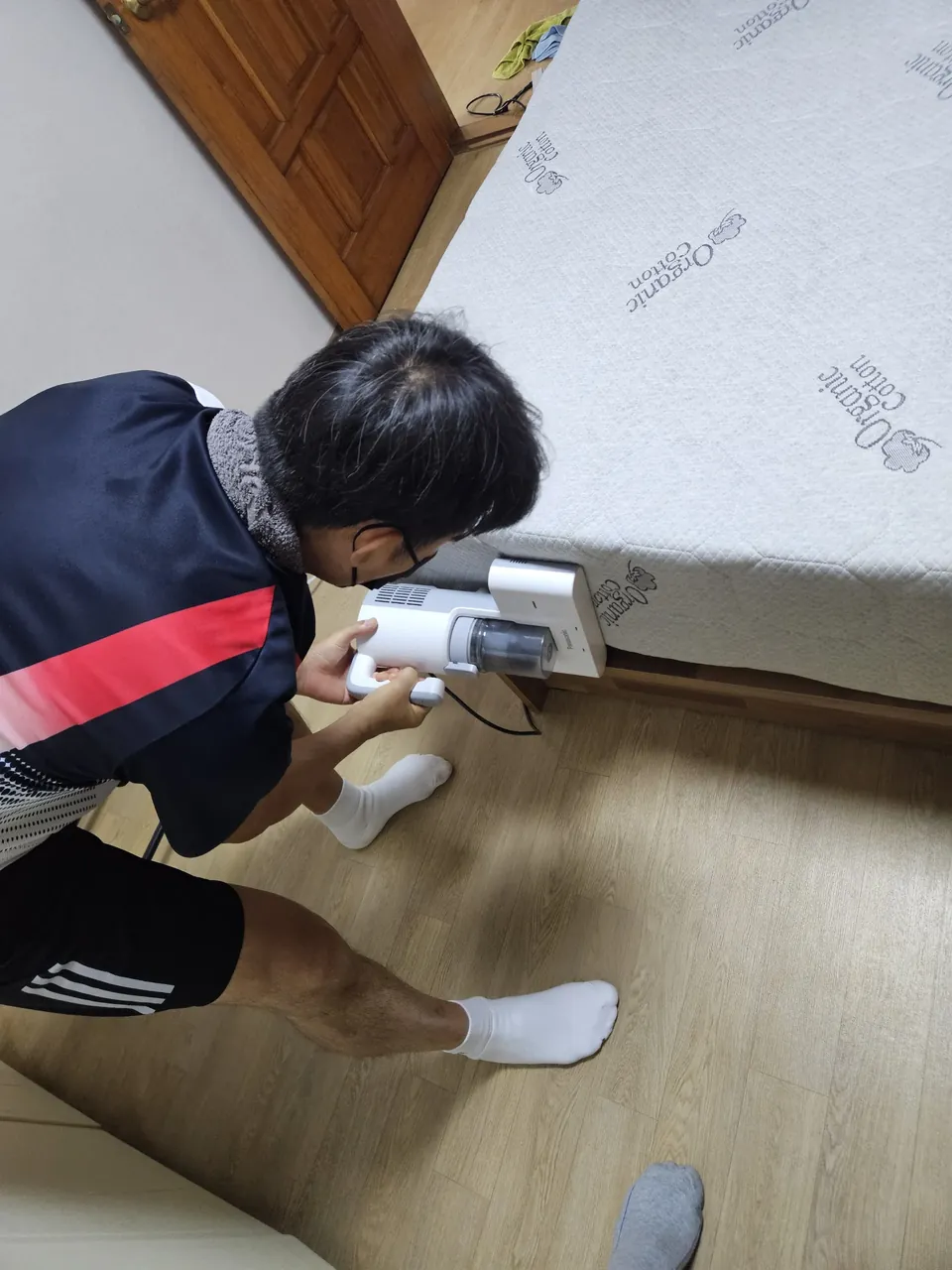 옆면 중간 부분을 침구청소기로 흡입하는 모습 — 오가닉 코튼 매트리스청소 2단계