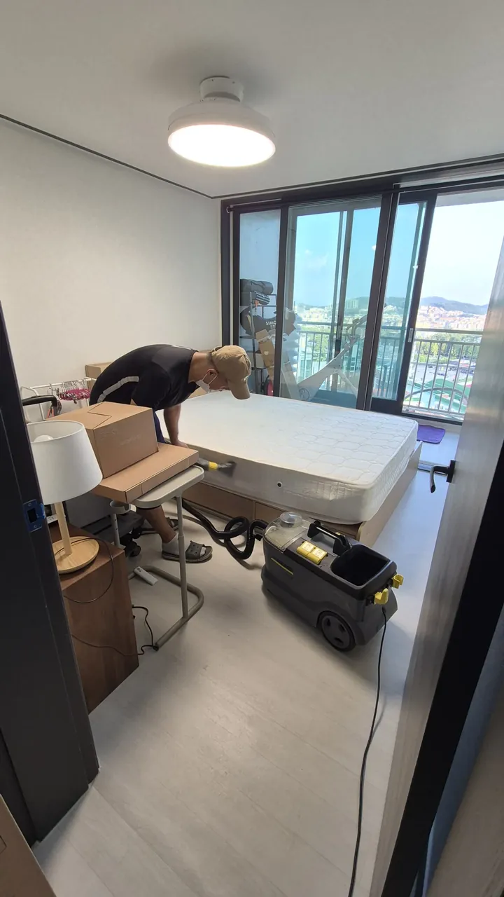 추출 장비를 옆에 두고 침대 매트리스를 작업하는 모습 — 아파트 매트리스청소 3단계